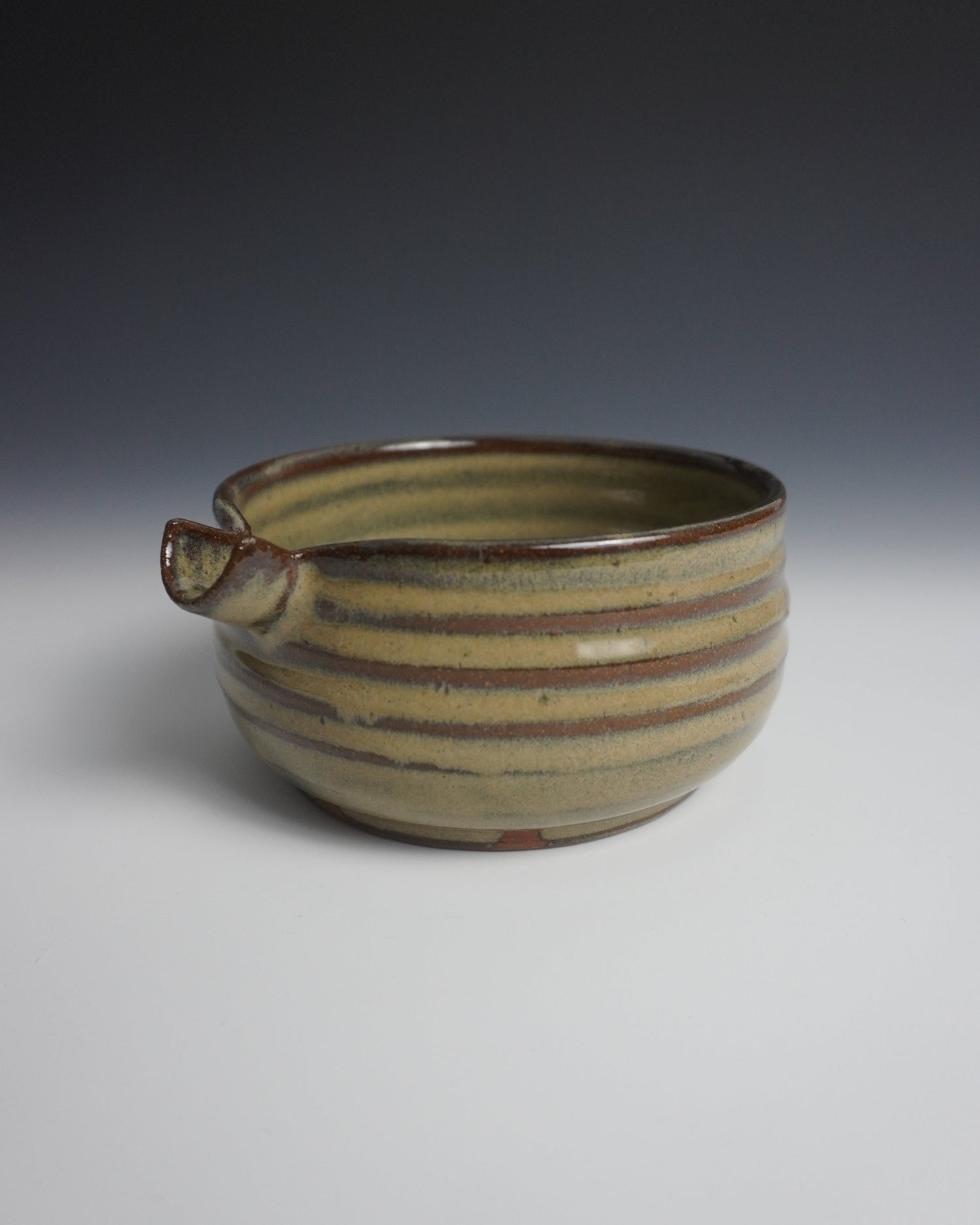 Ceramic vase with striped design on a gradient background